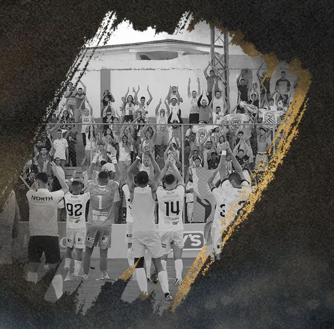 Torcida do North de braços erguidos na arquibancada, comemorando com os jogadores.